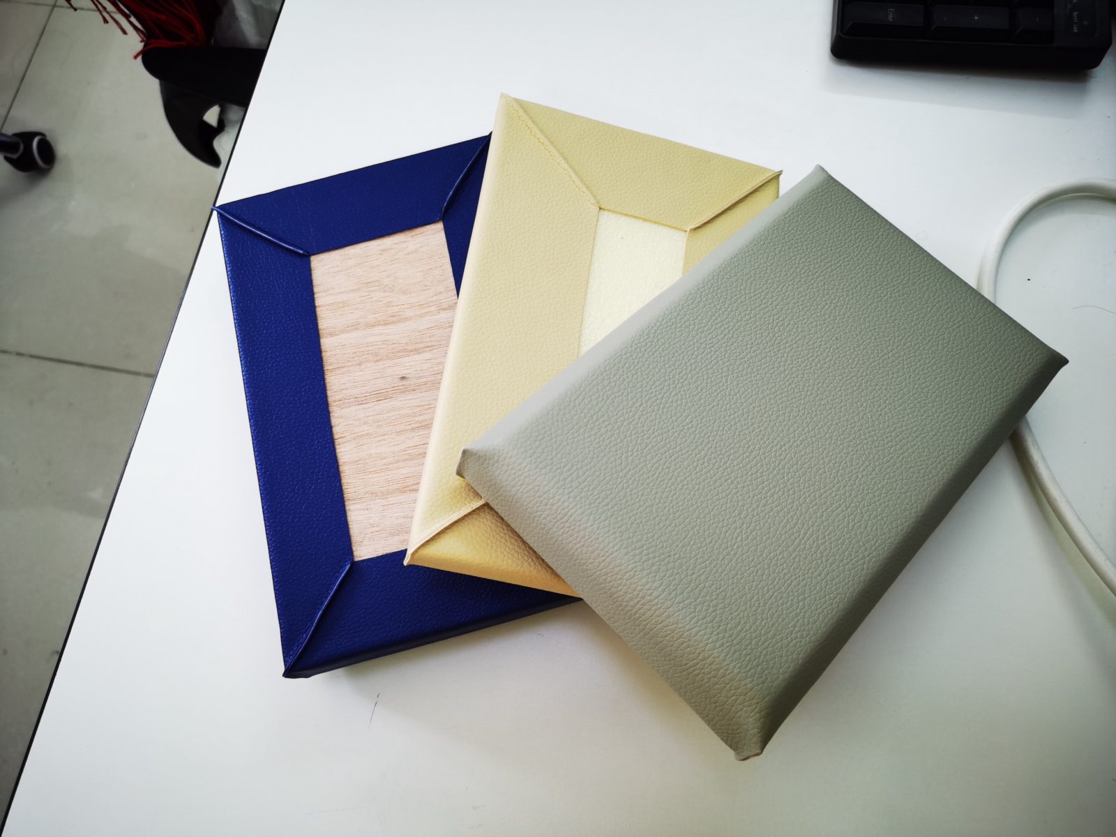 多种颜色皮革防撞软包墙板样品，展示木底板结构与包边工艺，用于办案区审讯室墙面防撞