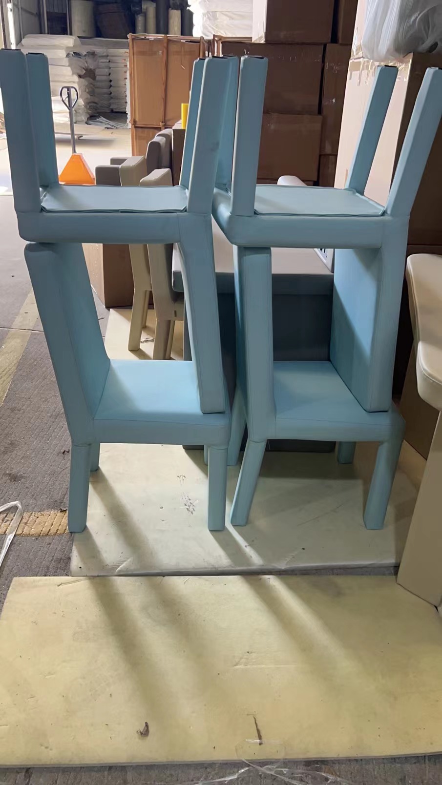 浅蓝色皮革软包防撞椅成品堆叠,高密度海绵填充圆角防撞设计,适用于办案区审讯室留置室防撞家具