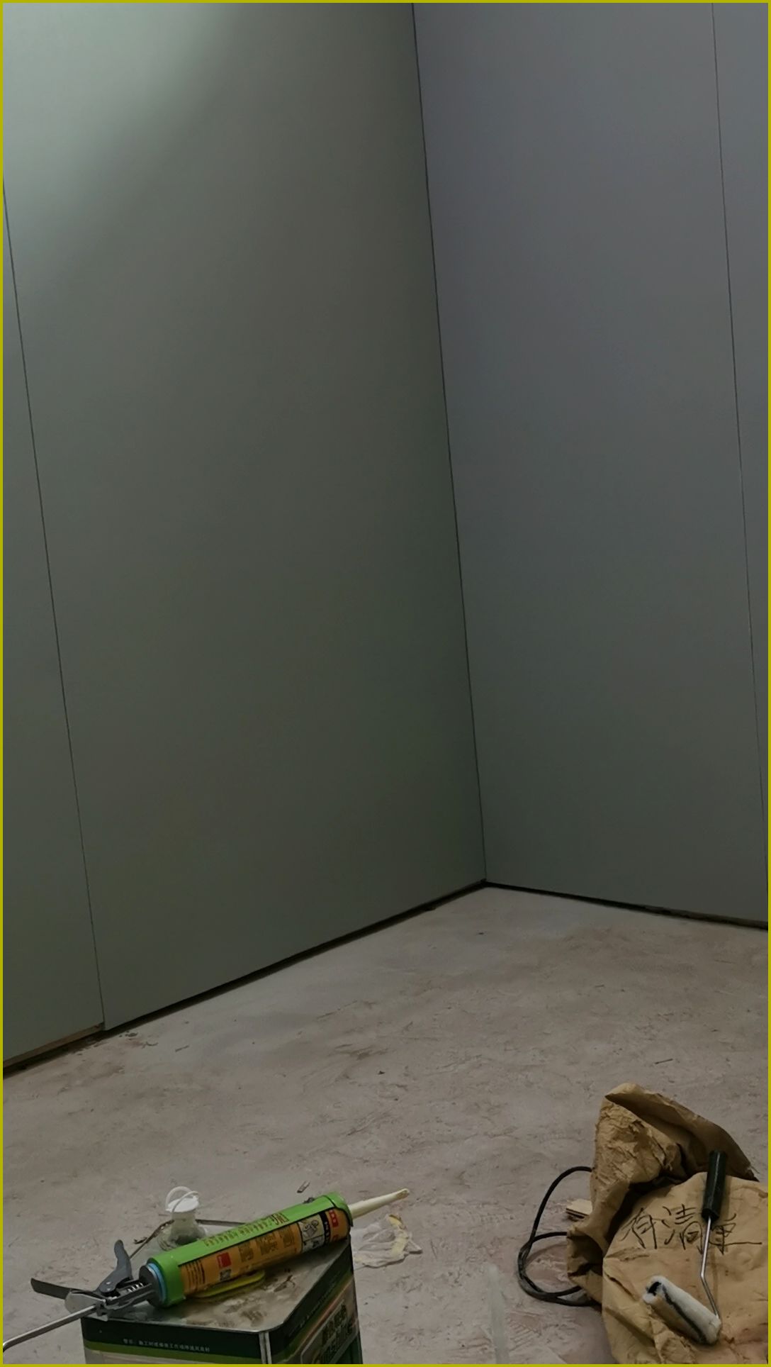 办案区审讯室防撞软包墙面安装施工现场，软包墙板满铺墙面并进行打胶密封处理