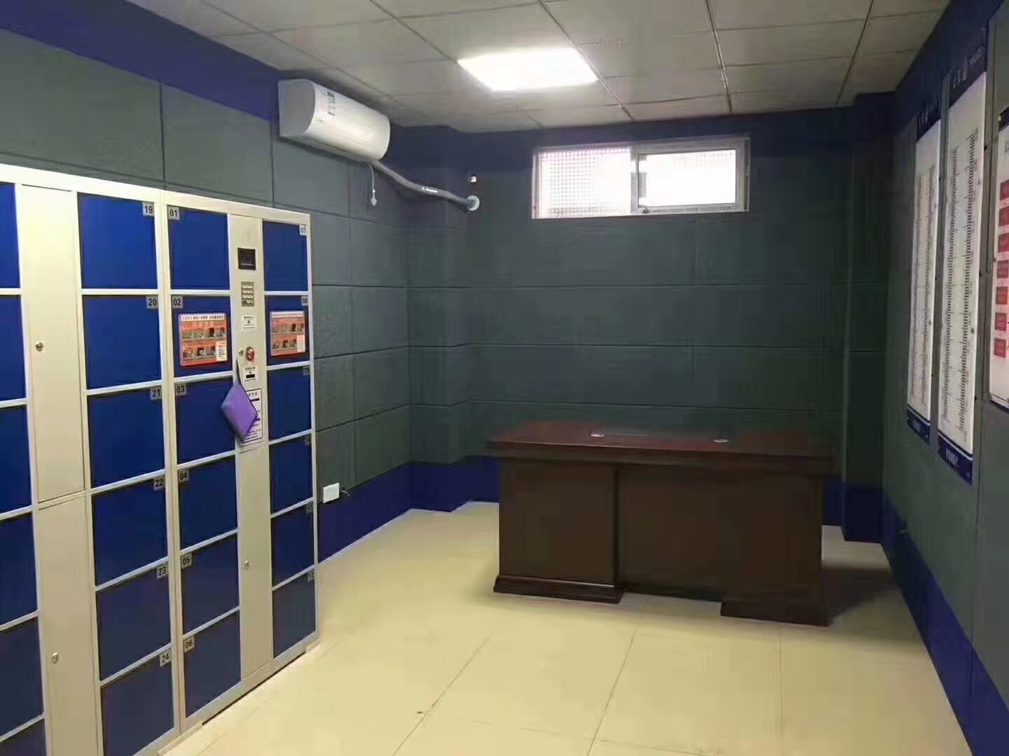 询问室深绿色防撞软包墙面整体装修实景，软包墙板搭配蓝色墙裙，适用于公检法办案区防撞防自伤