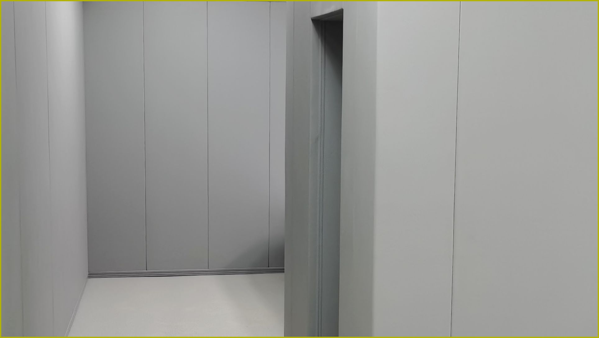 办案区审讯室灰色防撞软包墙板整体安装实景，高密度海绵软包墙面满铺配防撞地脚线，防自伤防撞处理