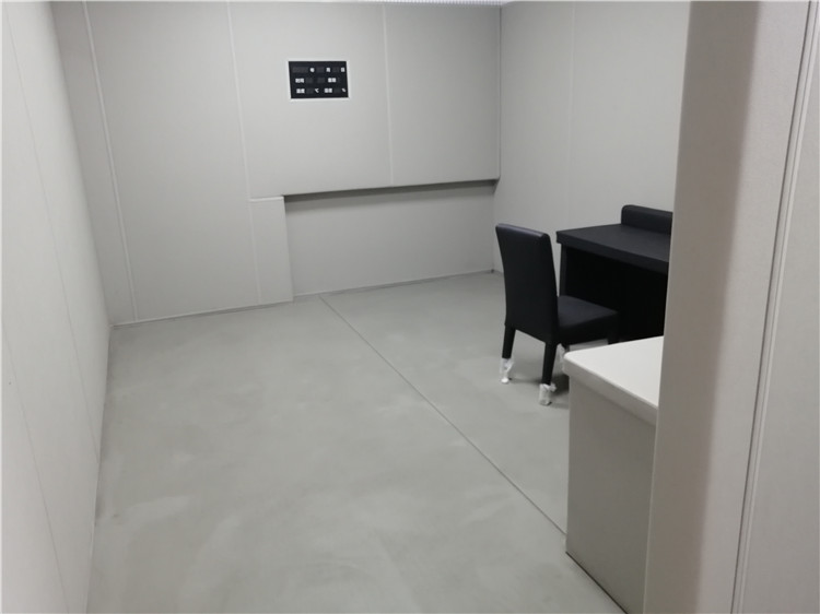 办案区询问室灰色防撞软包墙面整体装修实景，软包墙板搭配桌椅适用于审讯室防自伤设计
