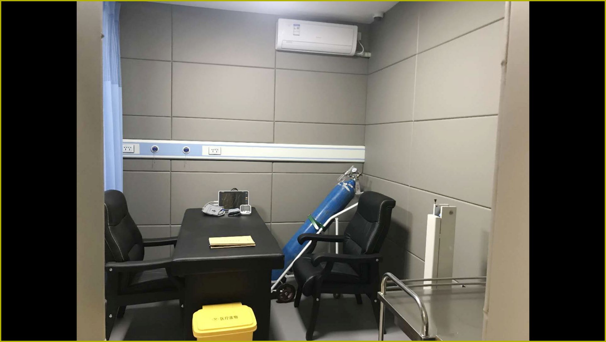 留置室医务室灰色防撞软包墙面整体实景，高密度海绵软包墙板搭配防撞桌椅防自伤设计