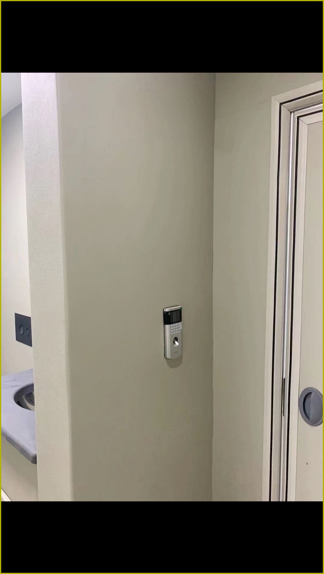 办案区审讯室米色皮革防撞软包墙面安装实景，圆角包边搭配门禁指纹锁，高密度海绵防自伤设计