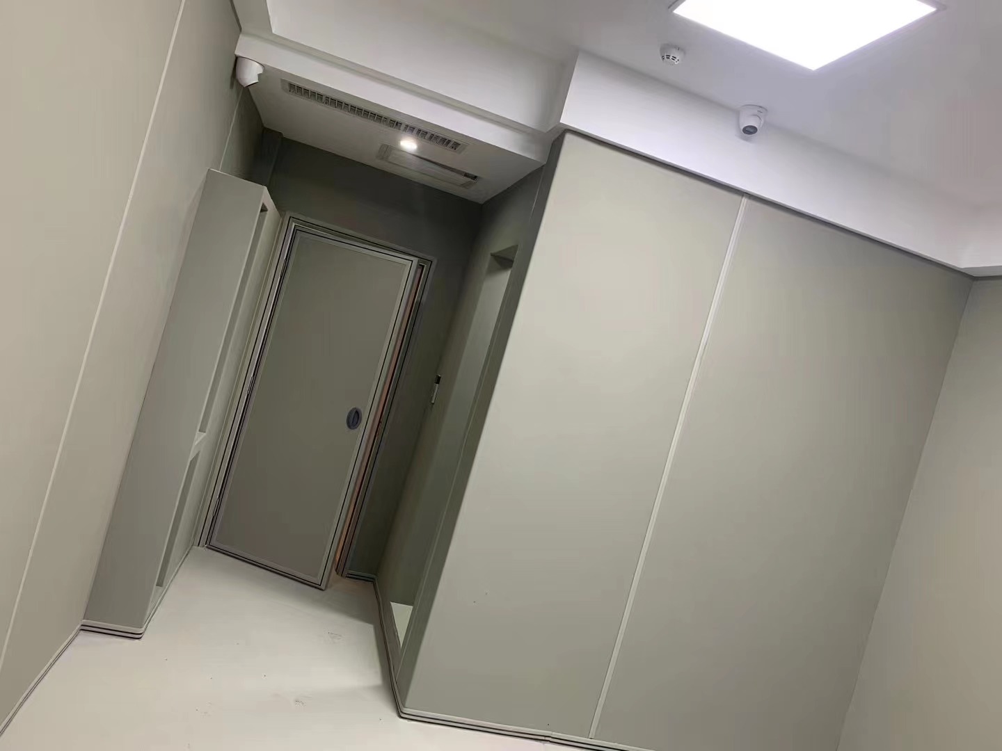 审讯室灰色防撞软包墙面整体安装实景,软包墙板搭配防撞门,高密度海绵包覆防自伤设计