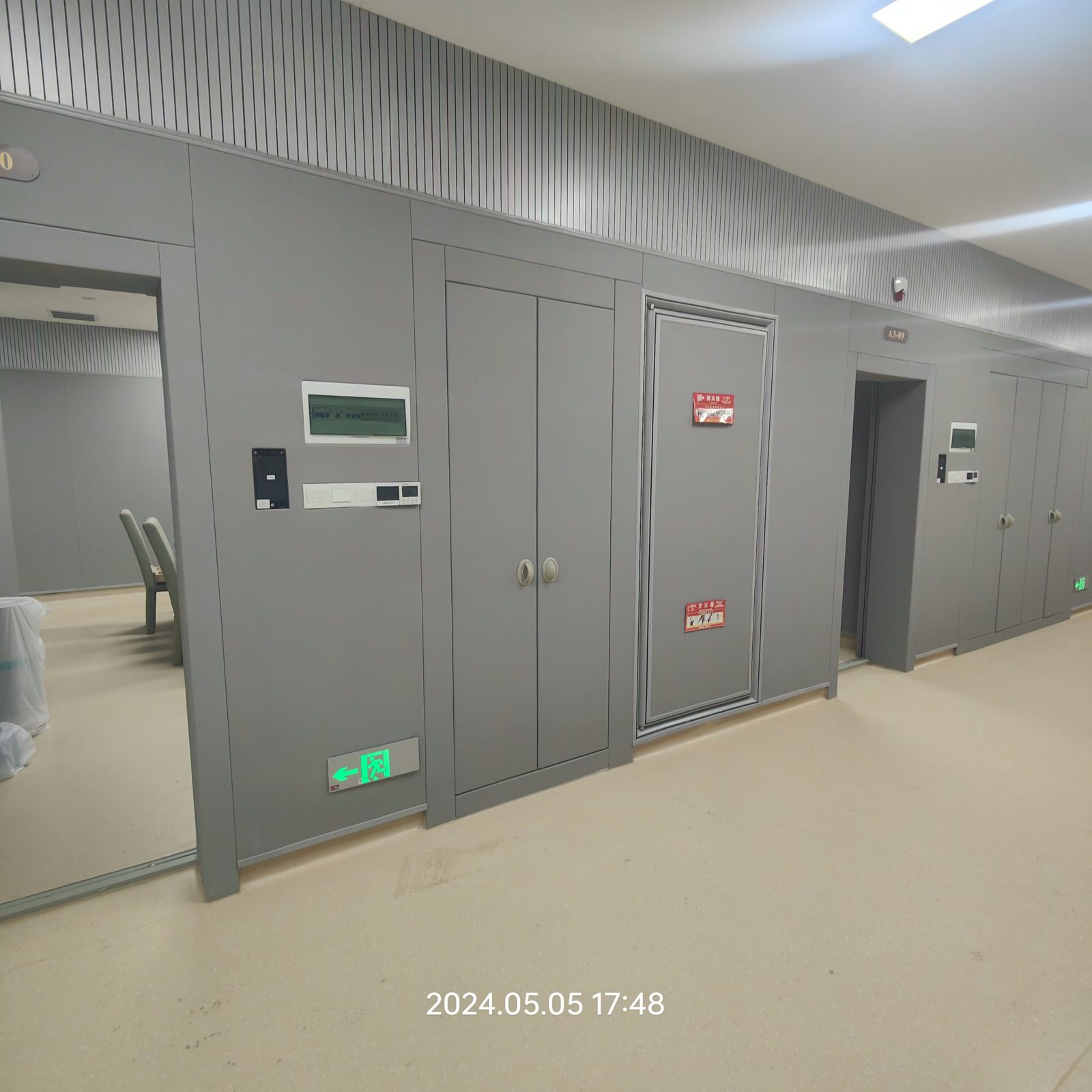 留置室办案区灰色防撞软包墙面与防撞门安装实景,高密度海绵软包防自伤设计