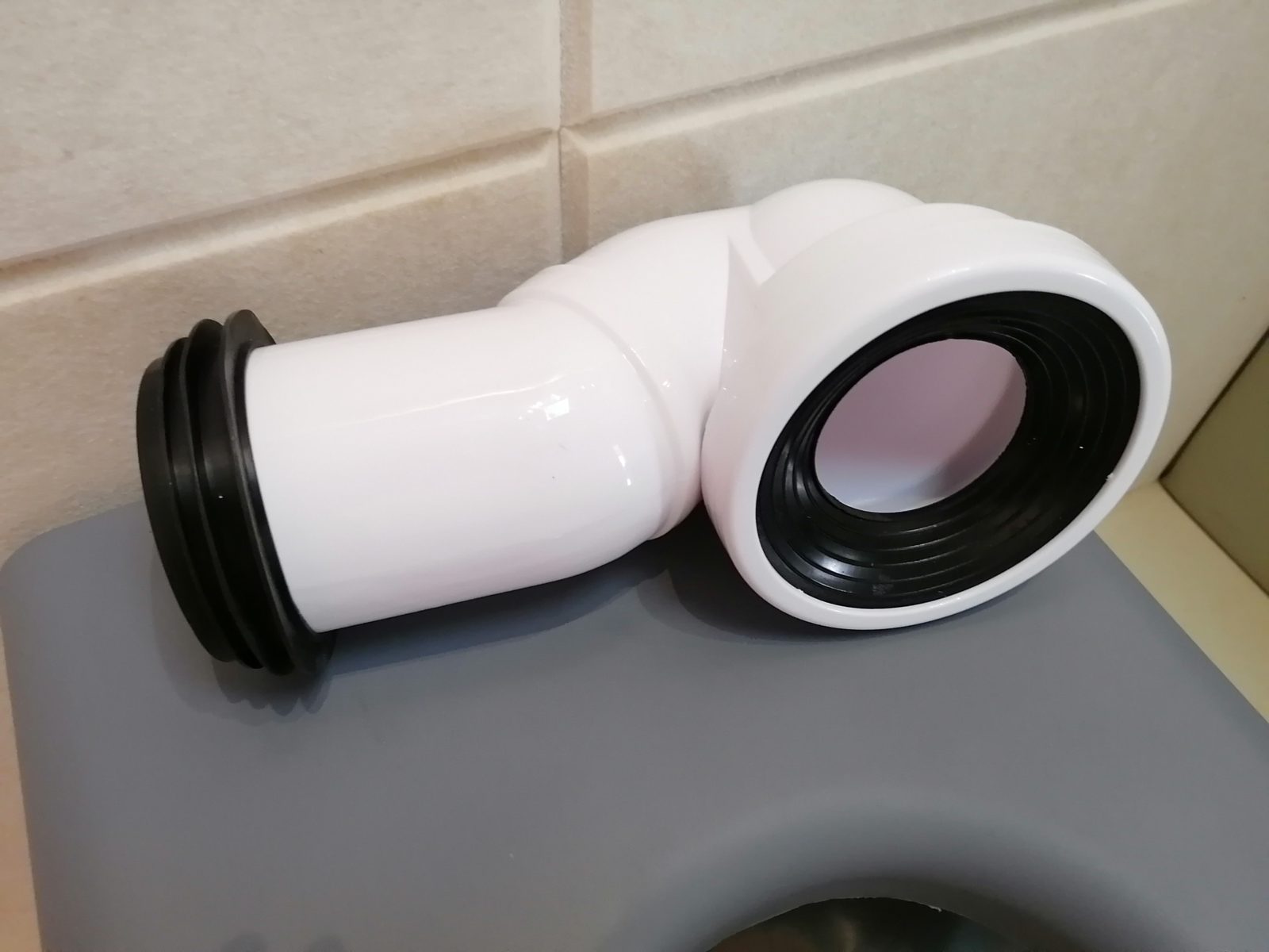 白色PVC马桶移位弯头连接器，两端配黑色橡胶密封圈，用于防撞马桶排污管移位密封连接安装