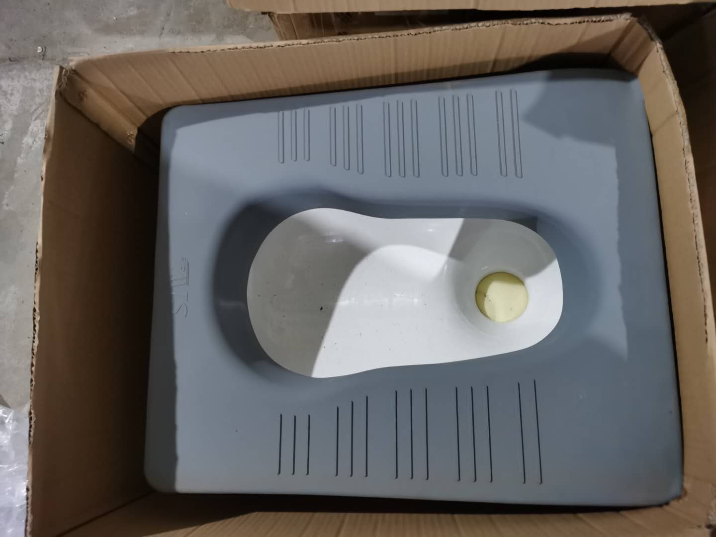 灰色软包防撞蹲便器，白色陶瓷便池搭配高密度海绵防撞包边，适用于办案区留置室防自伤设计
