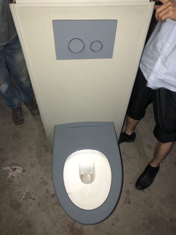 办案区留置室防撞马桶,米色皮革软包包覆箱体,灰色座圈配双按键冲水,防自伤卫浴设施
