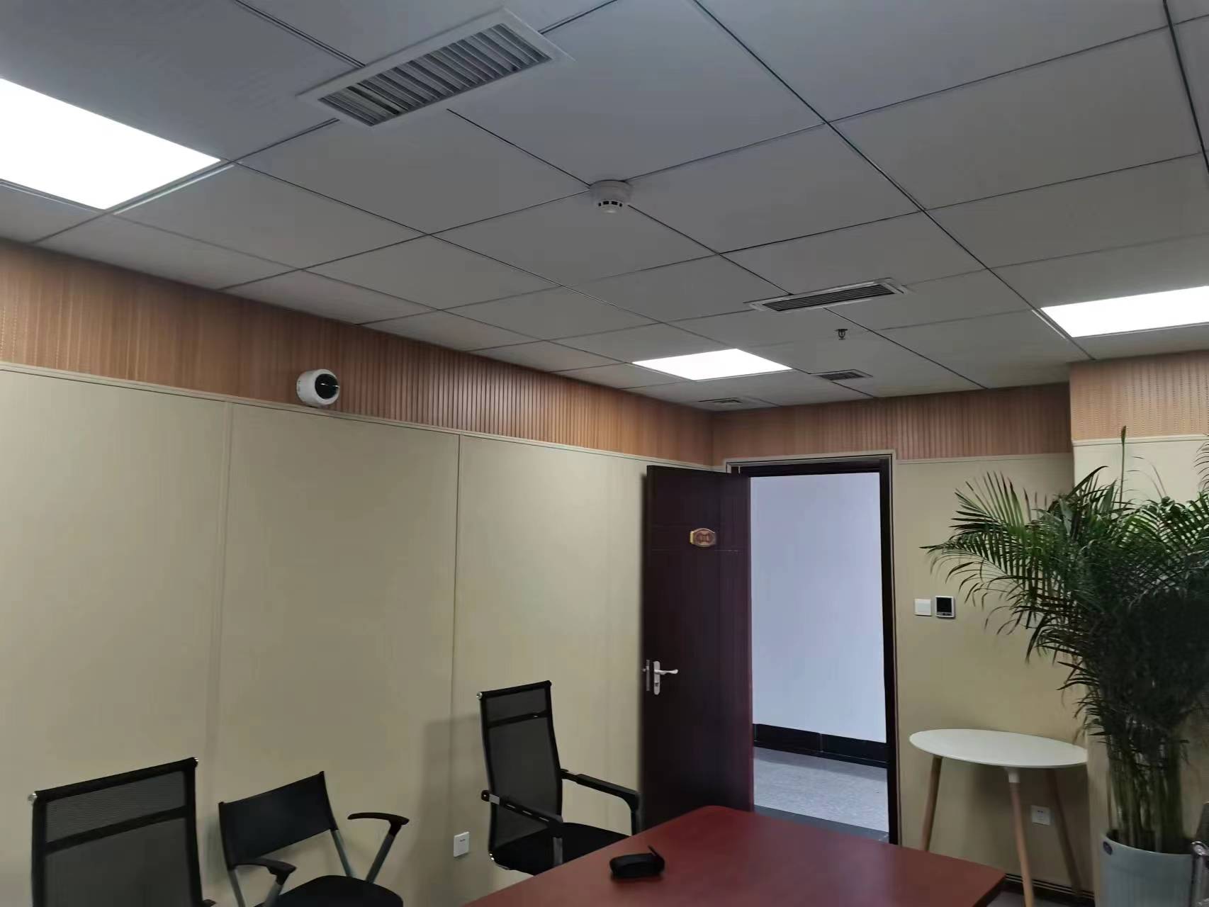 会议室米色布艺软包吸音板墙面装修实景,搭配木饰面腰线和集成吊顶,办公空间声学降噪装饰