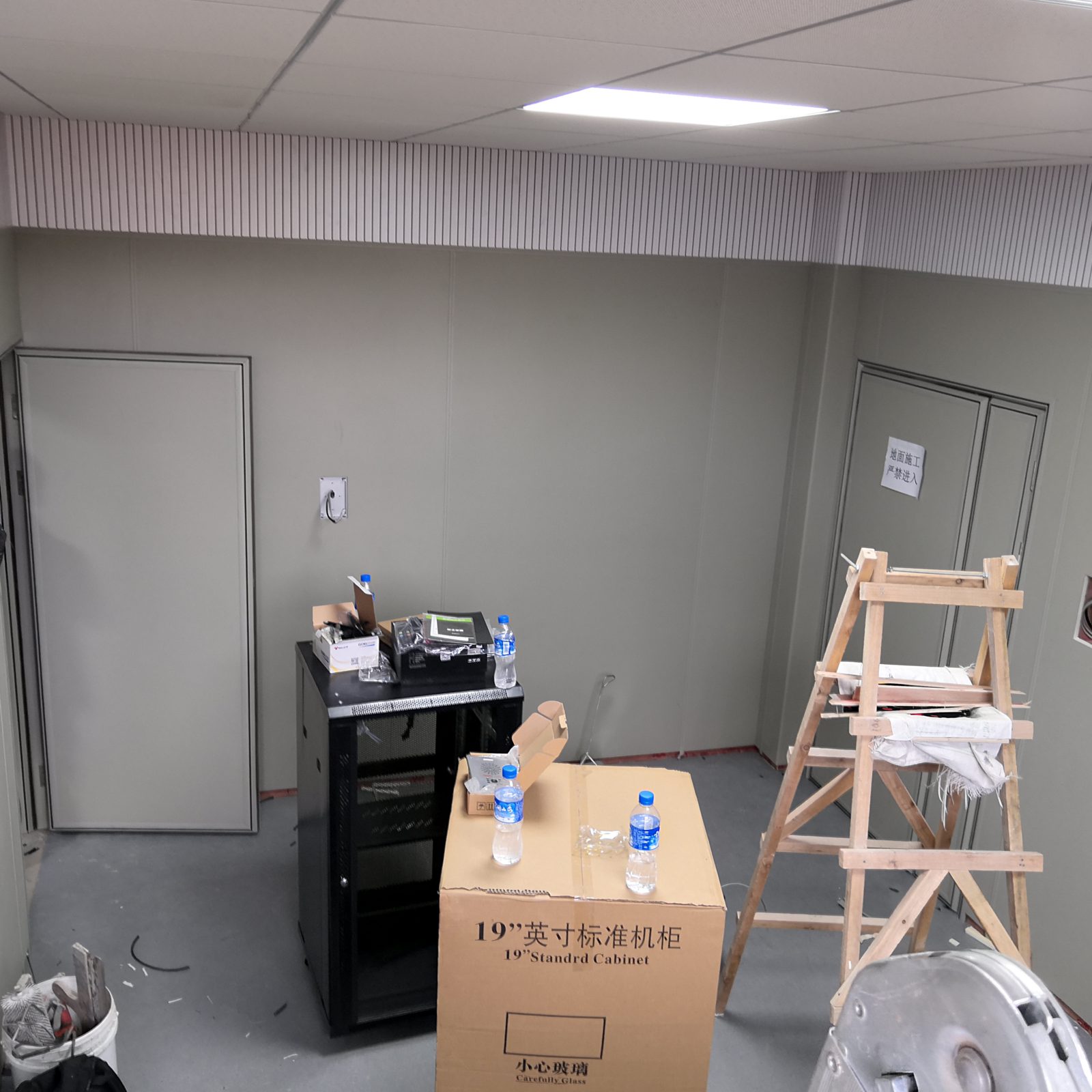 隔音房内部声学装修实景,白色槽木吸音板墙裙搭配矿棉板吊顶与金属隔音门,适用于设备机房降噪工程
